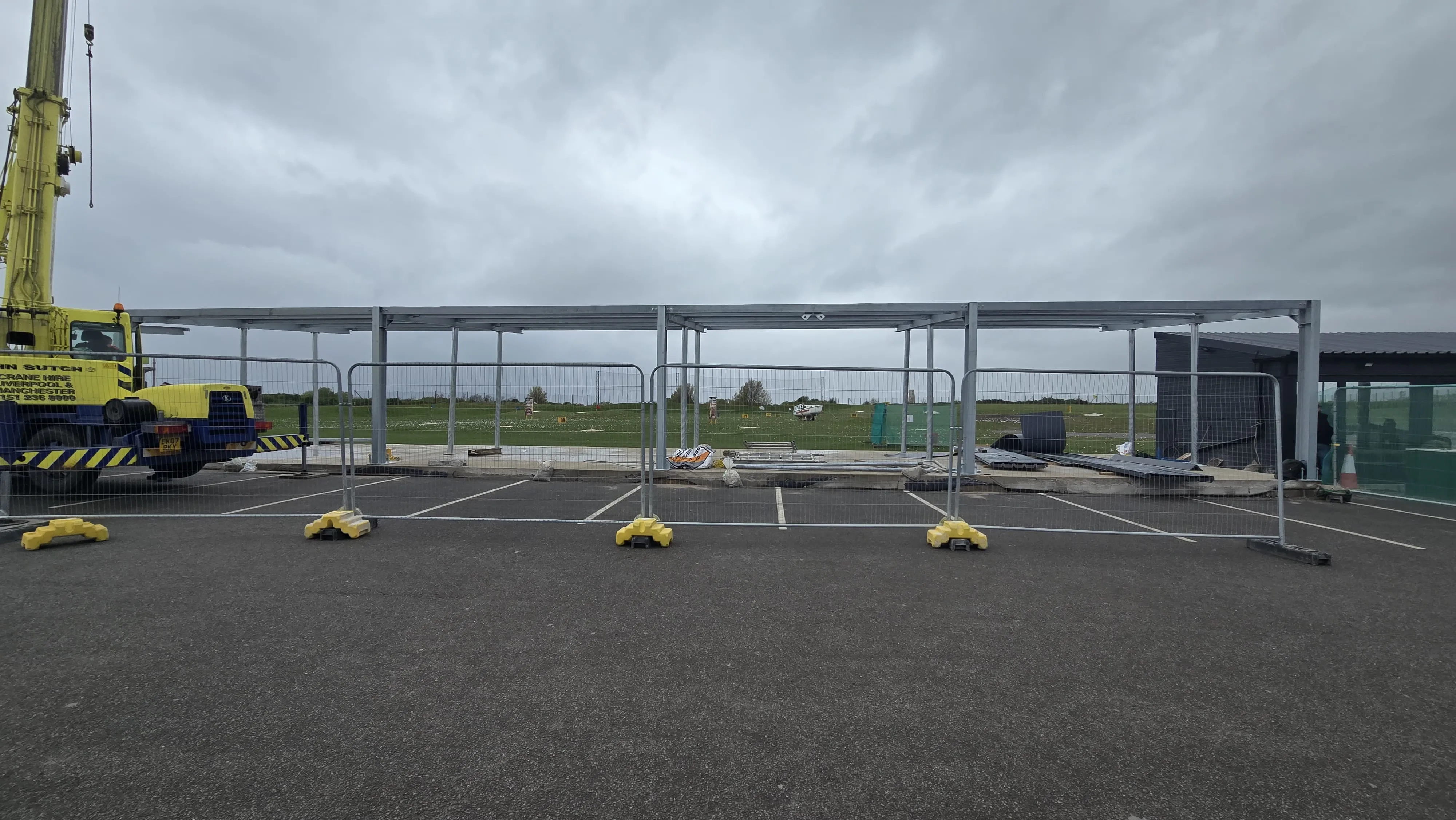Completed steel canopy frame spanning the driving-range bays at Moreton Hills Golf Centre, by MSR